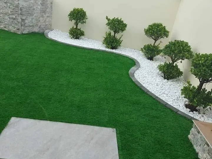 تنسيق حديقة منزلية بالعشب الصناعي والممرات